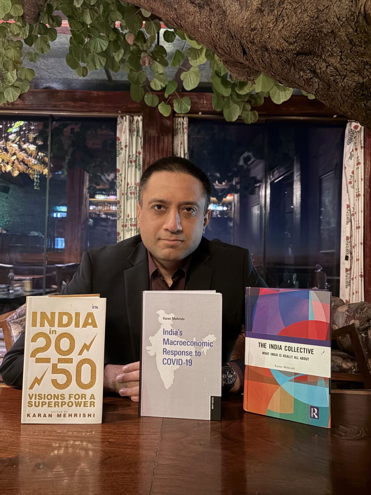 Karan Mehrishi seated behind his three books